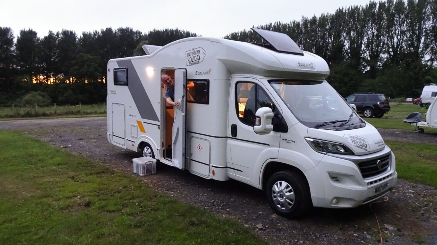 Peter looks out of the door of a motorhome as the sun sets on the first night of their post-lockdown family motorhome holiday